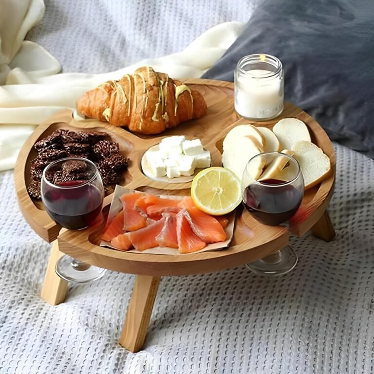 Tavolino rotondo in legno da picnic per il vino con formaggio e vino su una coperta