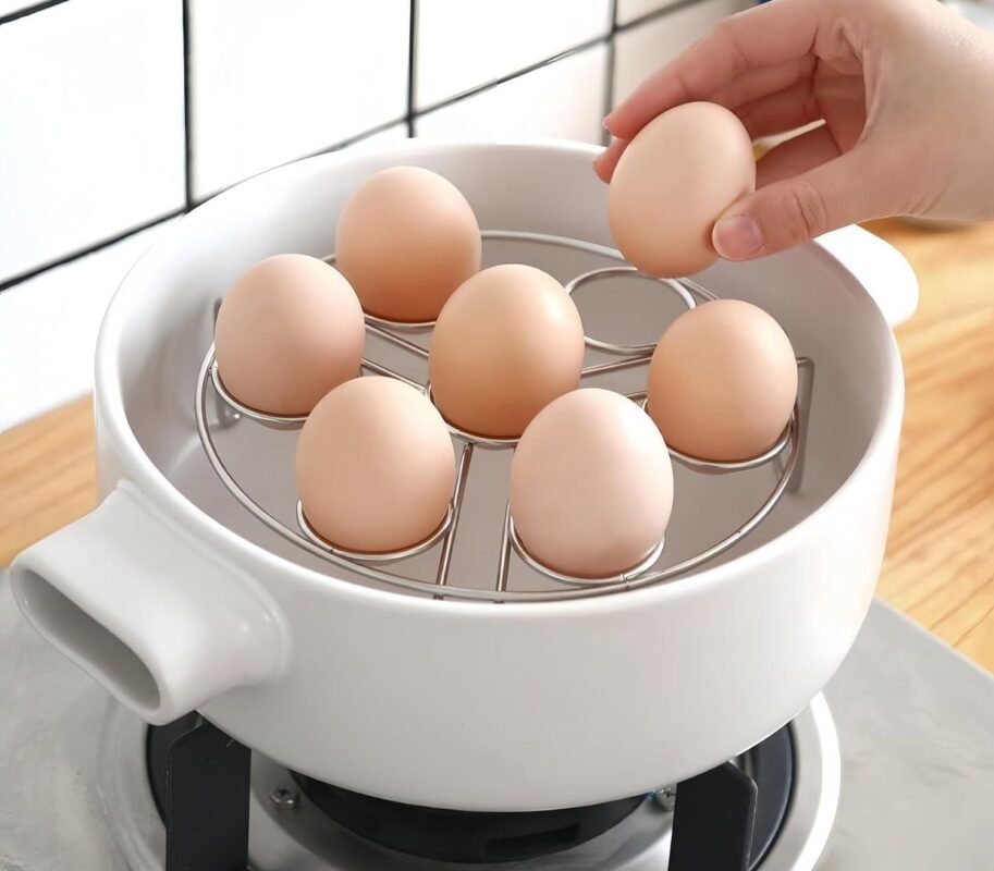 Portauova con sette uova dentro una pentola bianca sul piano cottura