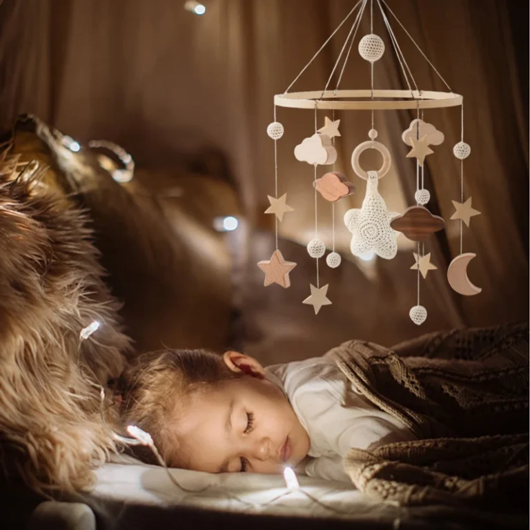 Giostrina in legno per neonati con stelle, nuvole e luna appesa sopra un bambino che dorme