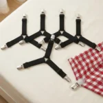 Fermalenzuola triangolari con clip regolabili disposti su un letto